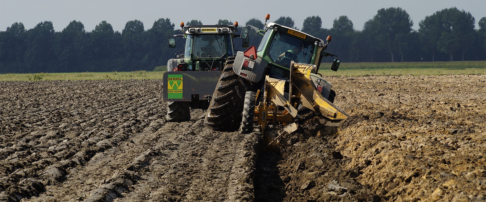 Twee Fendt-trekkers van Van Werven aan het diepploegen: de voorste hangt schuin in de open ploegvoor