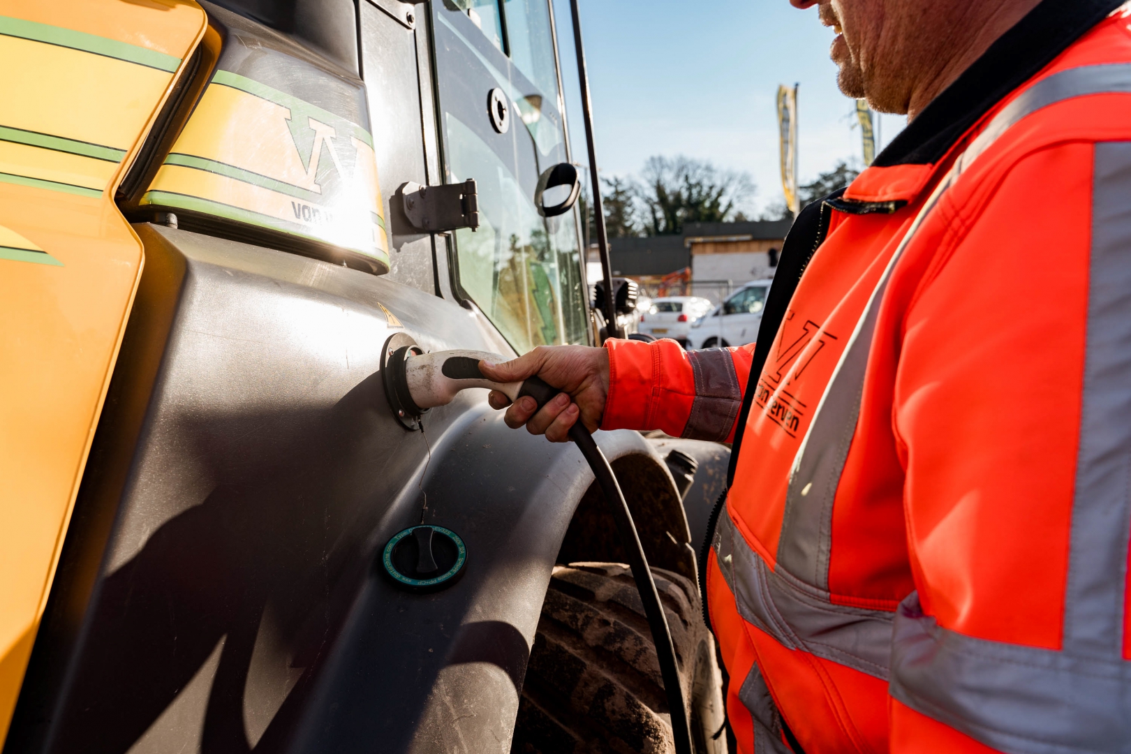 Machinist steekt de laadstekker in een elektrische machine van Van Werven