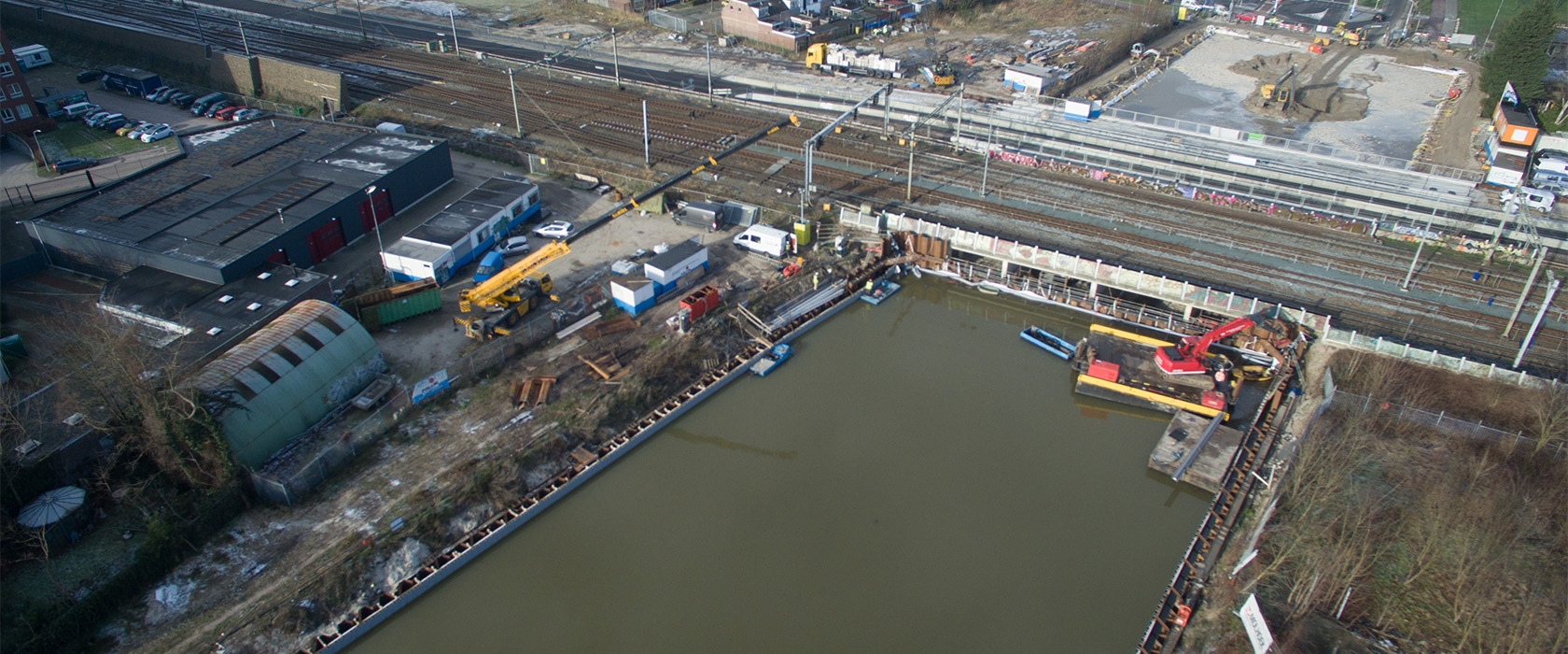 Luchtfoto van een met water gevulde foliebouwkuip naast het spoor
